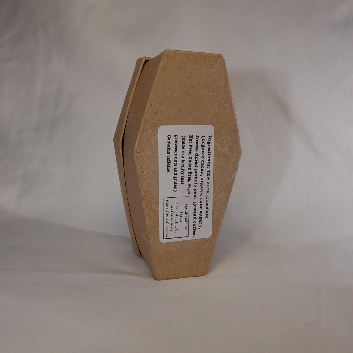 The backside of the cardboard coffin with the list of ingredients showing. The background is white.