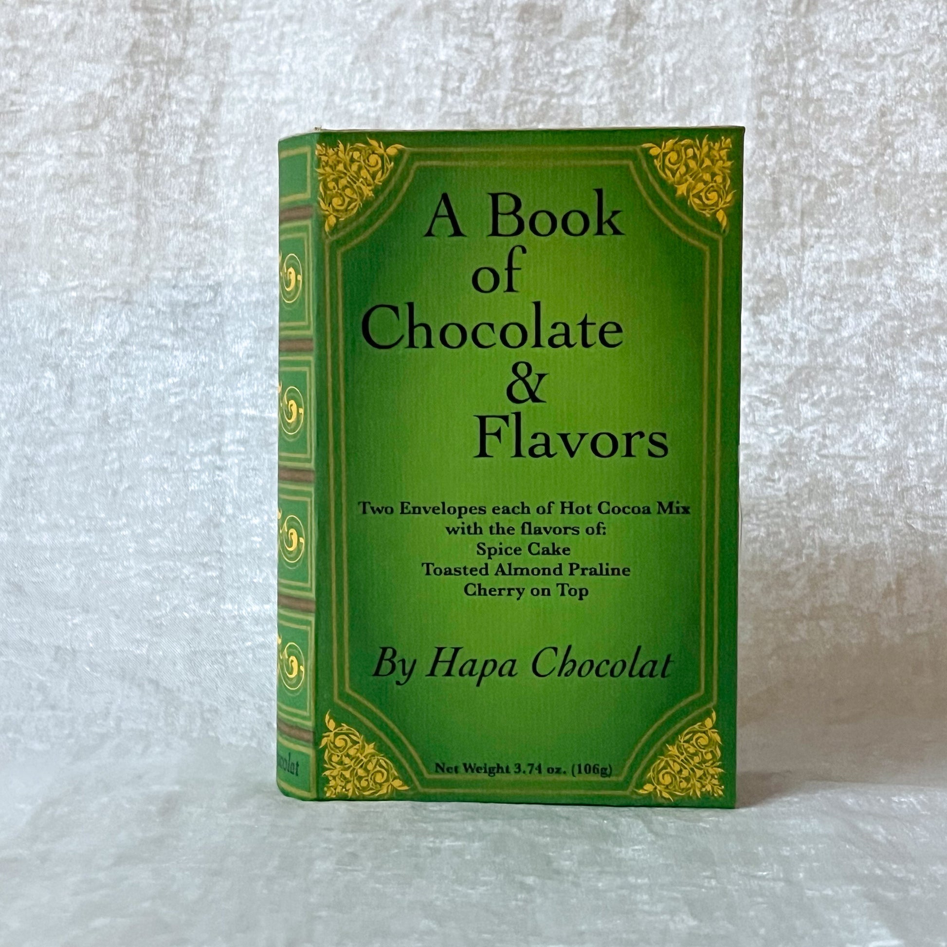 Green book titled 'A Book of Chocolate and Flavors' on a white fabric background.