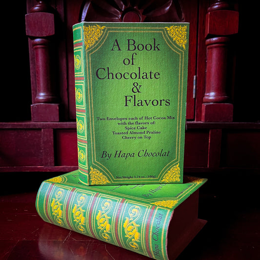 Green book titled 'A Book of Chocolate & Flavors' on a wooden surface.